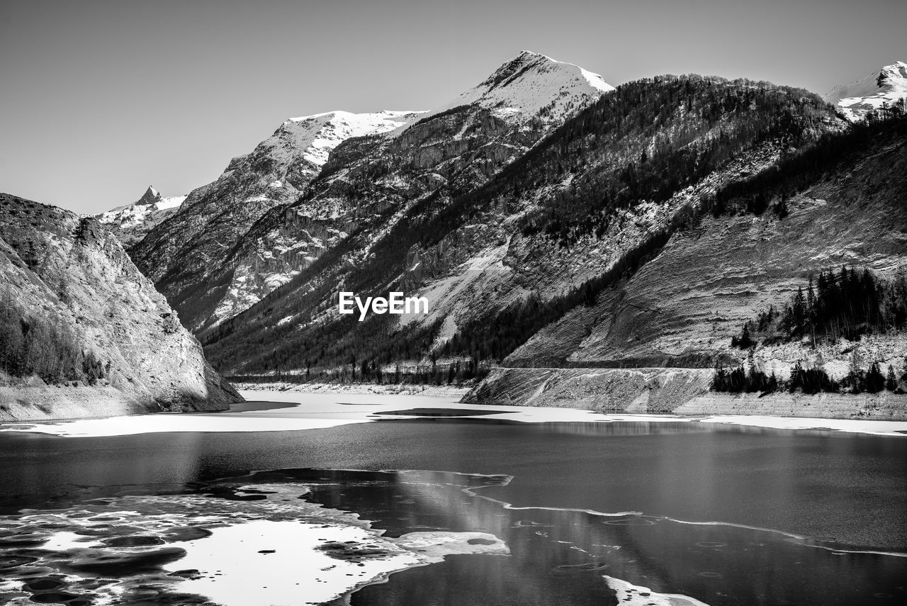 Scenic view of lake and mountains against clear sky