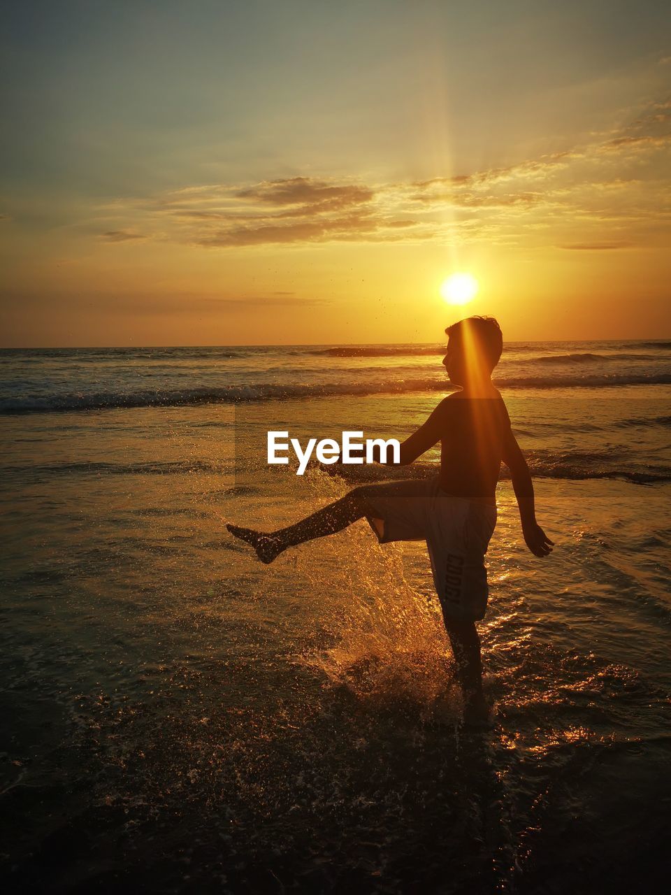 Boy on the  beach during sunset