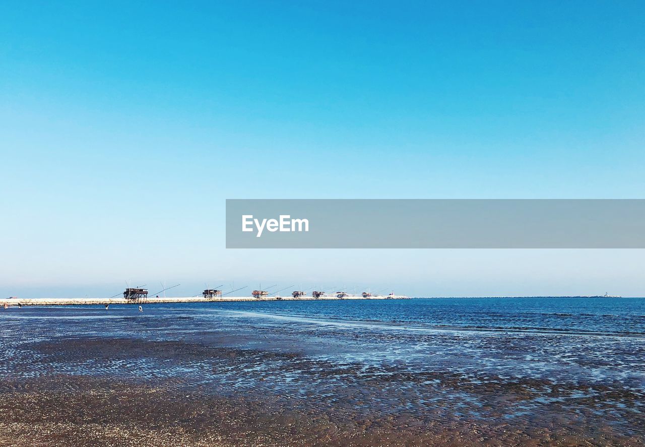 Scenic view of sea against clear blue sky