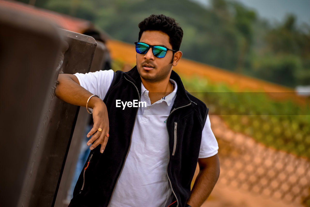 PORTRAIT OF YOUNG MAN WEARING SUNGLASSES