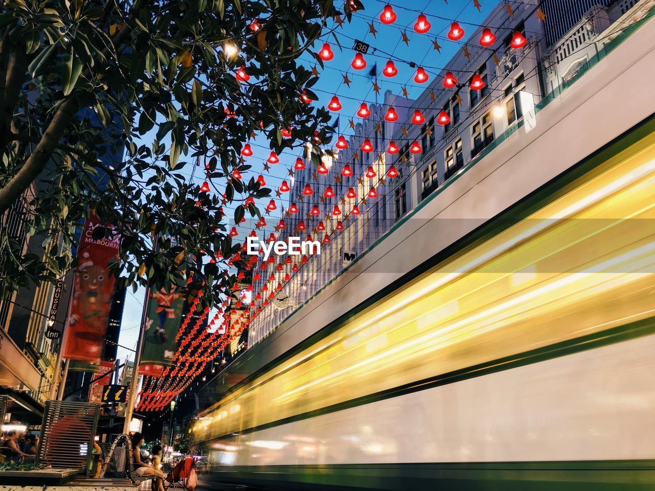 Blur image of cable car in city against decoration at dusk