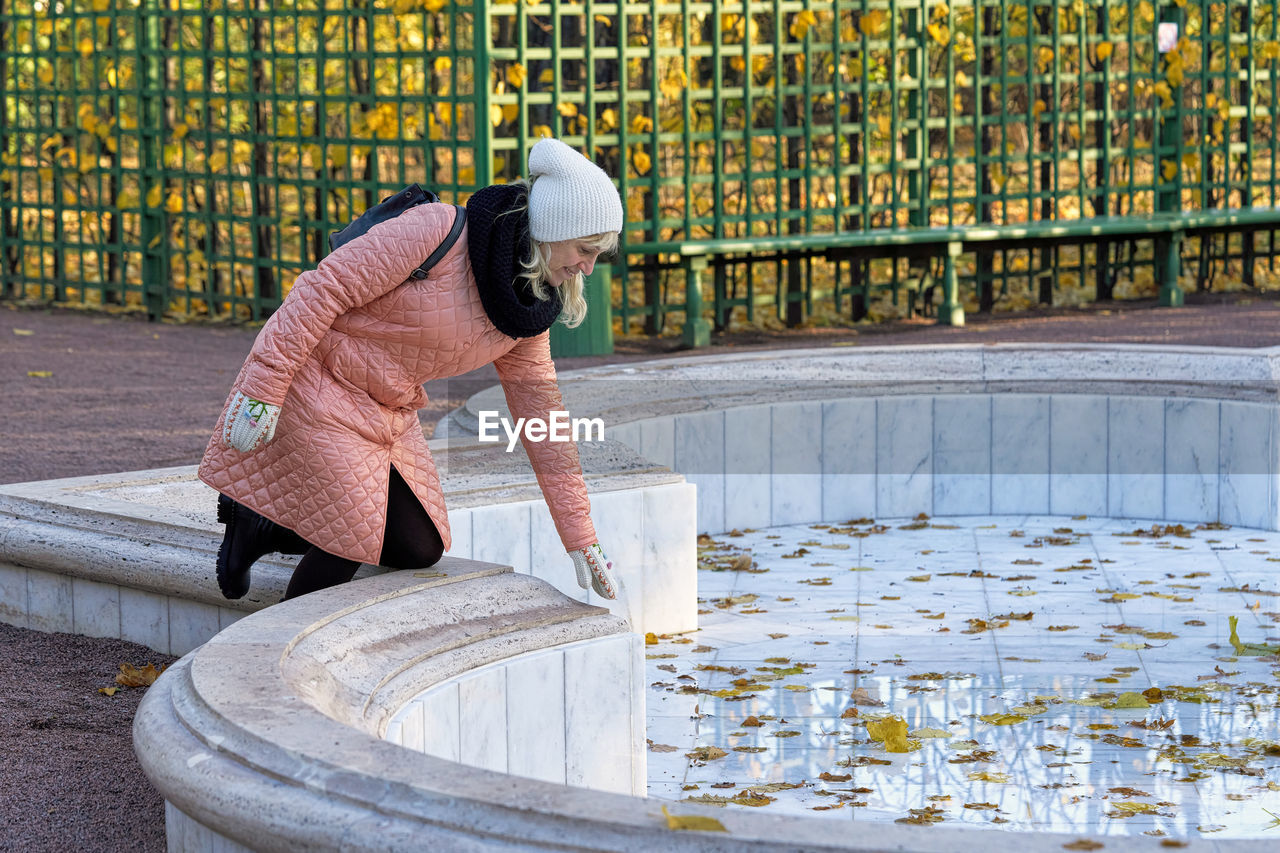 REAR VIEW OF MAN WORKING AT WATER