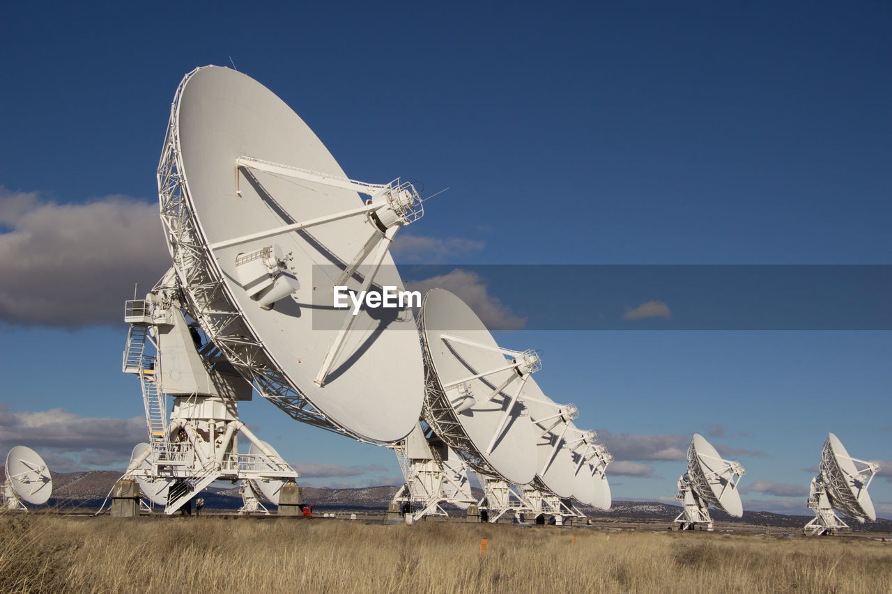 Low angle view of array on field against sky