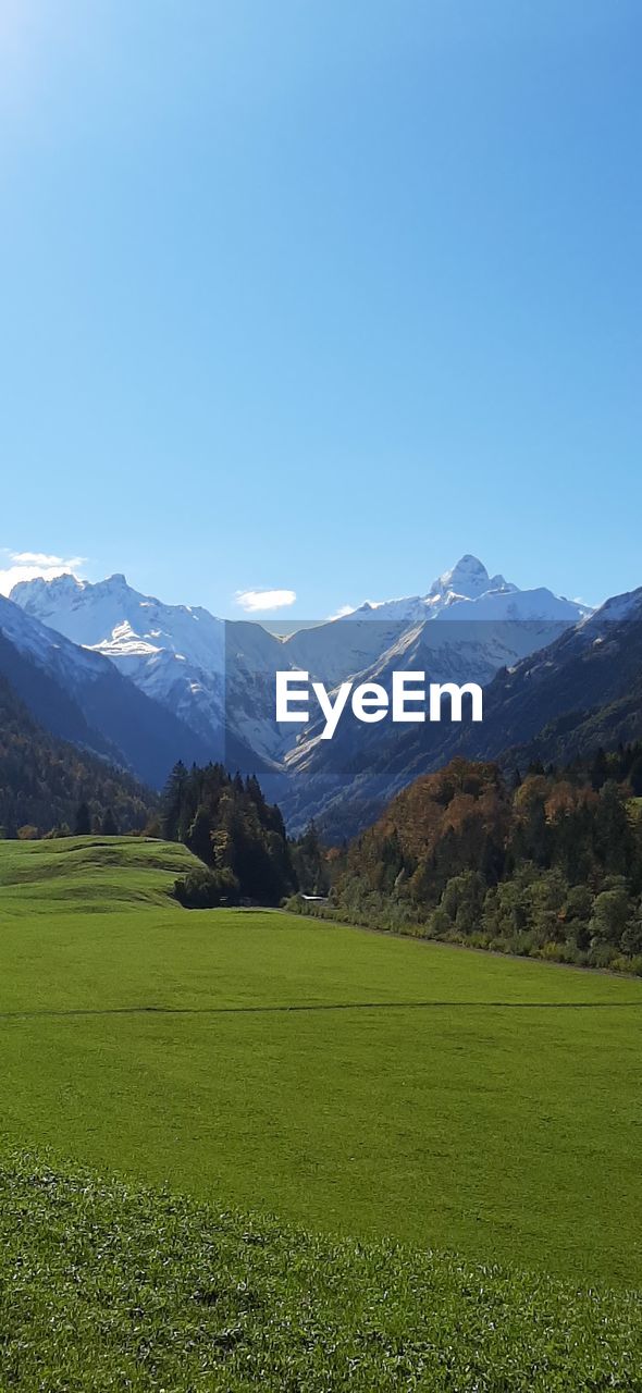 SCENIC VIEW OF FIELD AND MOUNTAINS AGAINST SKY