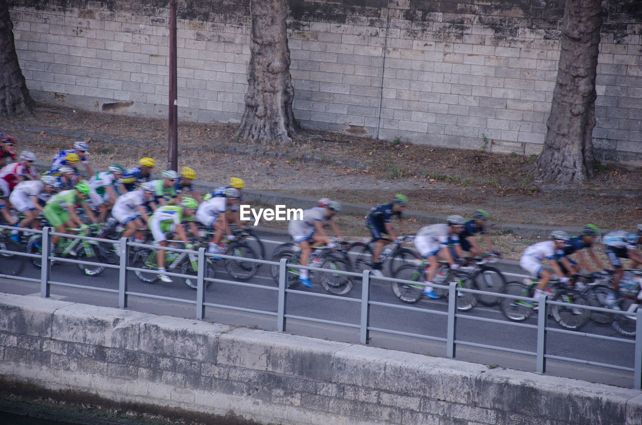 Blurred motion of people riding bicycle on road