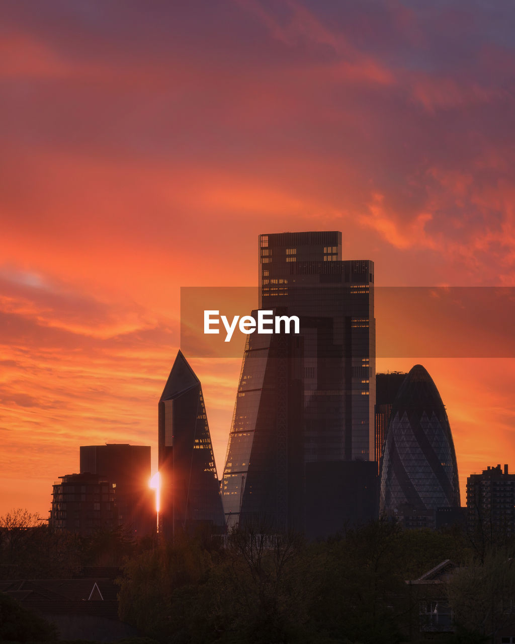 Low angle view of buildings against orange sky