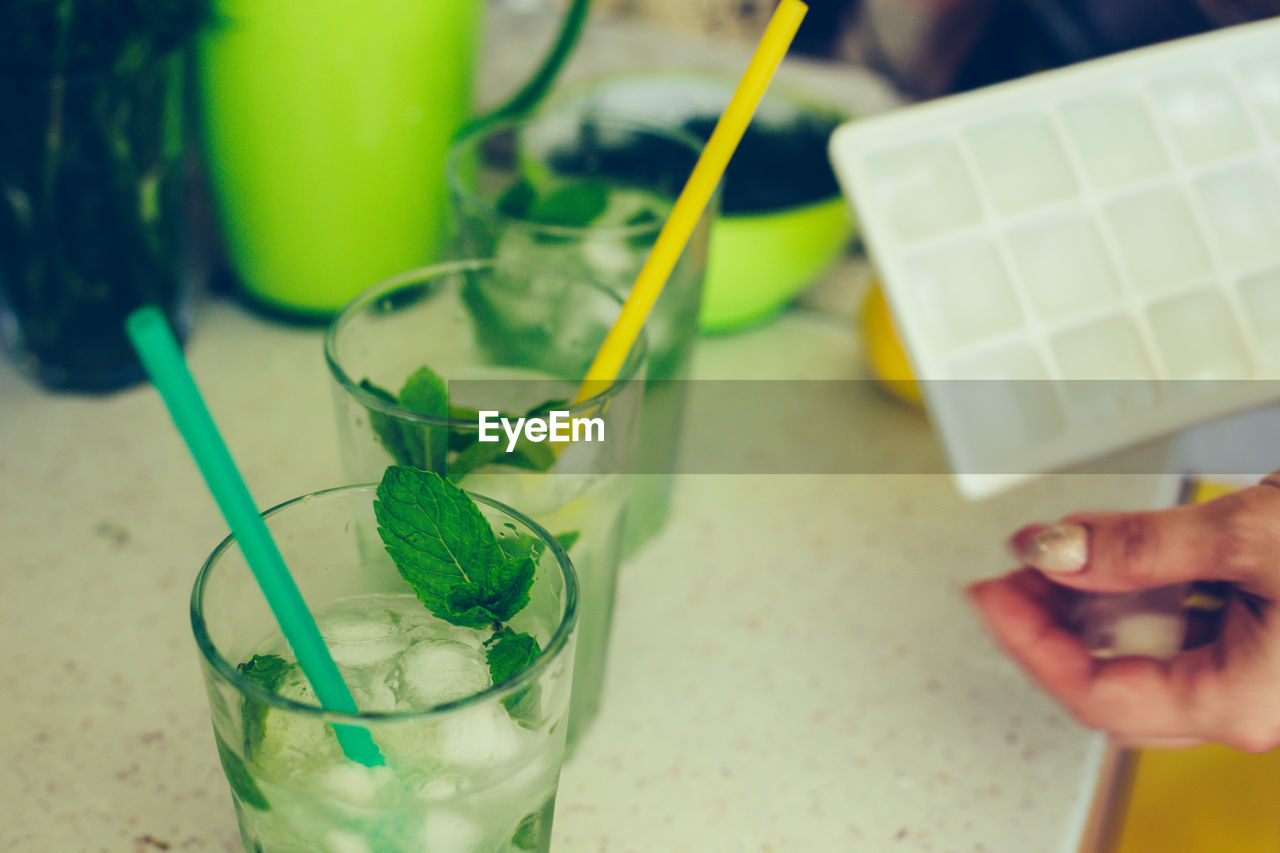 CROPPED IMAGE OF HAND HOLDING DRINK WITH WINEGLASS