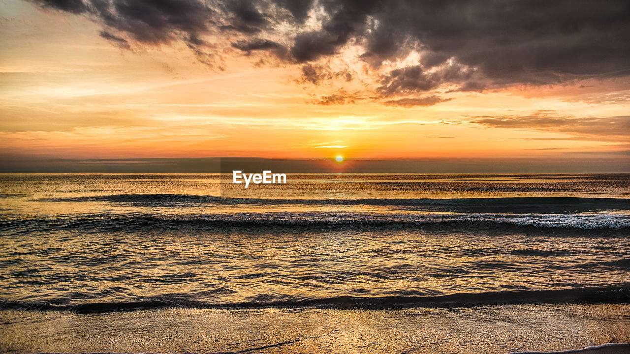 SCENIC VIEW OF BEACH DURING SUNSET