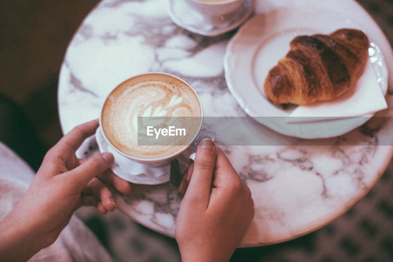 MIDSECTION OF WOMAN HOLDING COFFEE