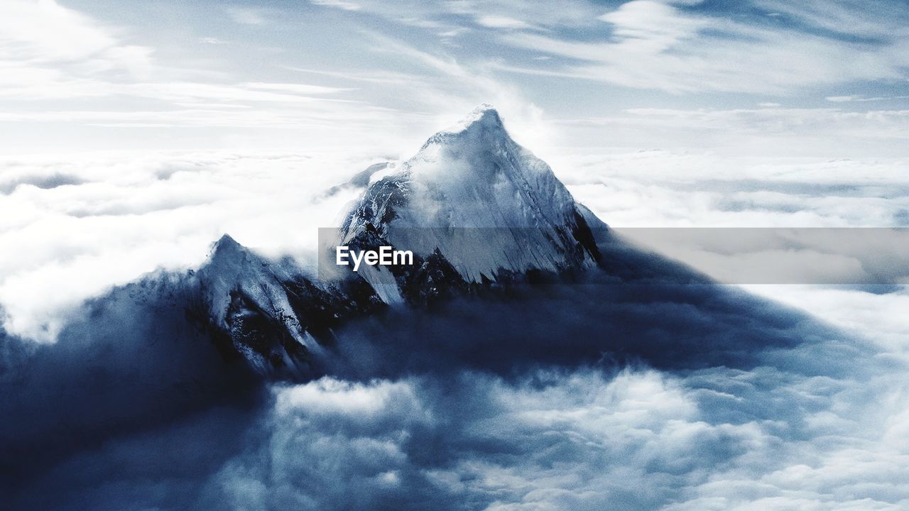 Scenic view of snowcapped mountains against cloudy sky