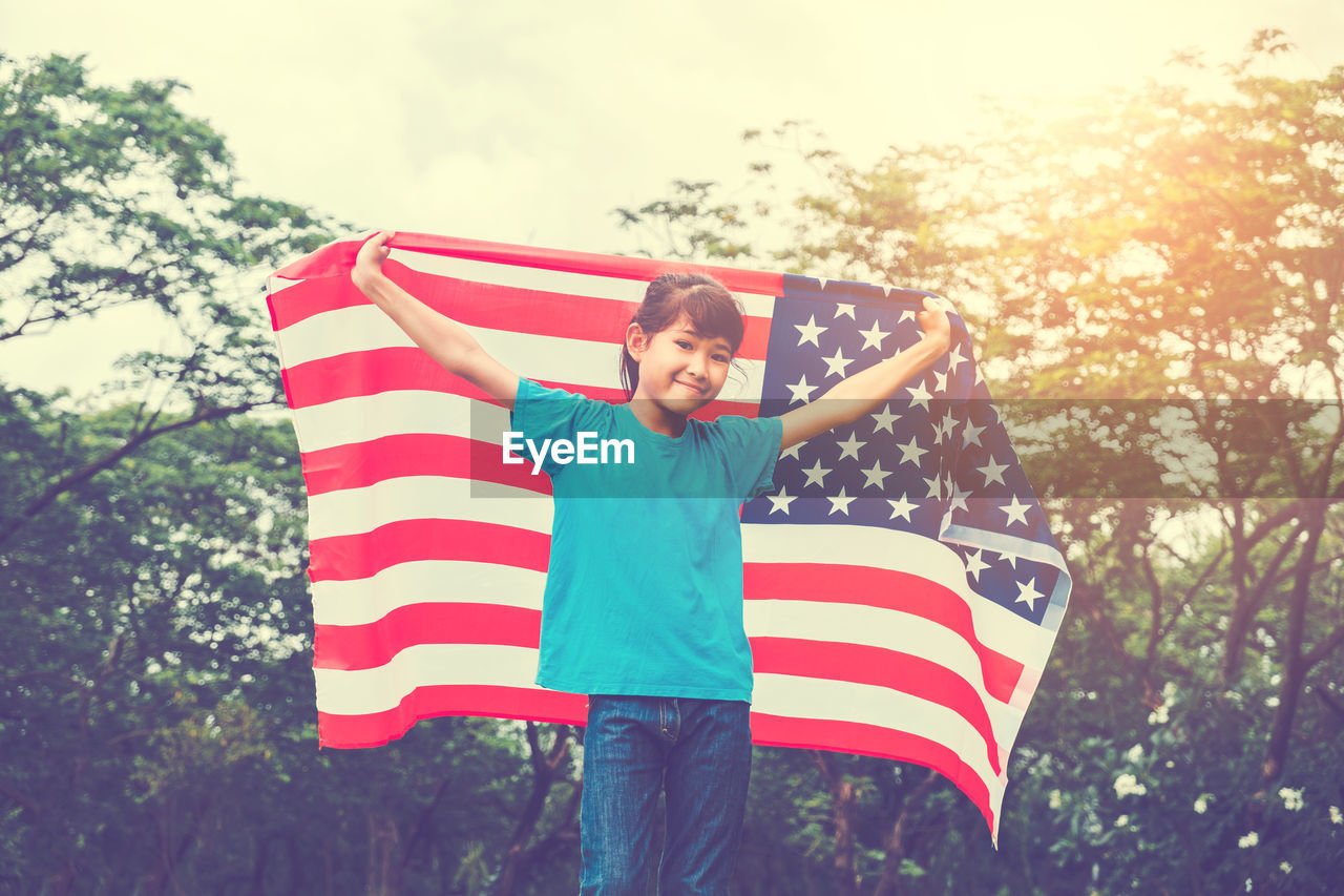 Girl holding american flag on field