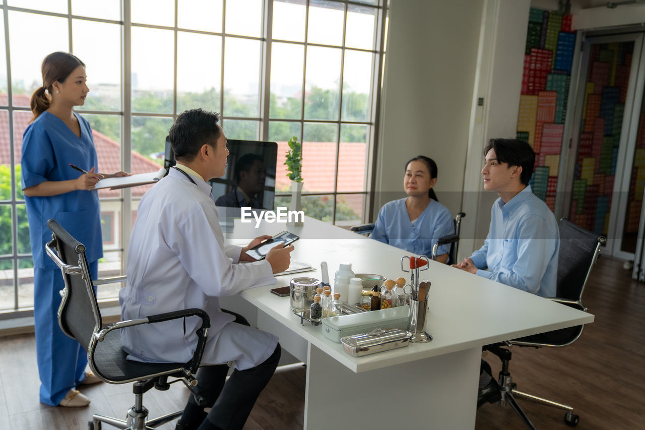 portrait of young woman using mobile phone in office