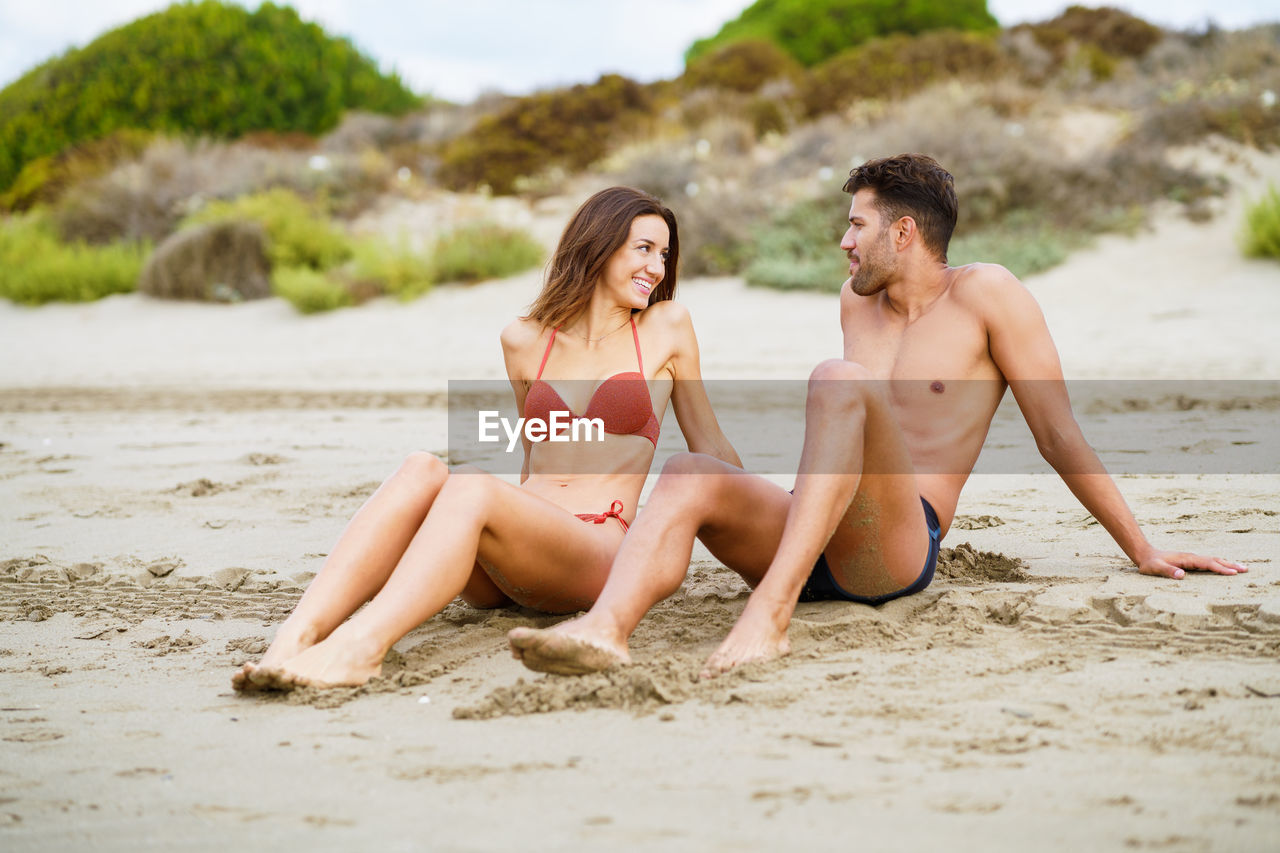 Young couple sitting at beach