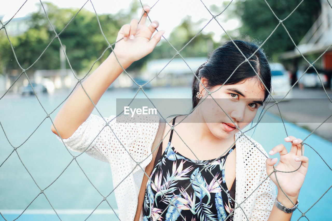 Portrait of woman seen through net in court