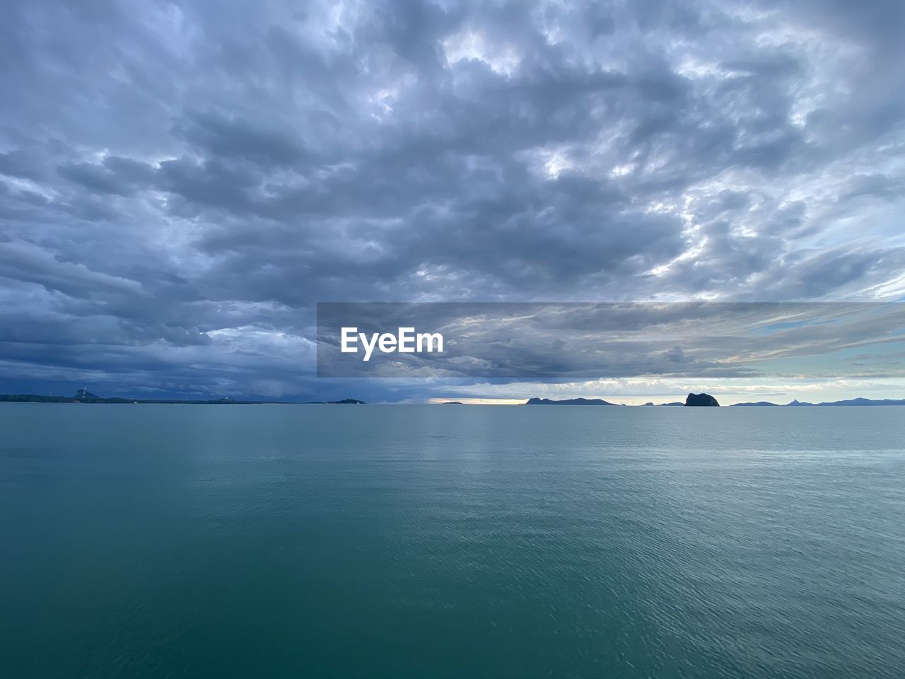 SCENIC VIEW OF SEA AGAINST STORM CLOUD SKY