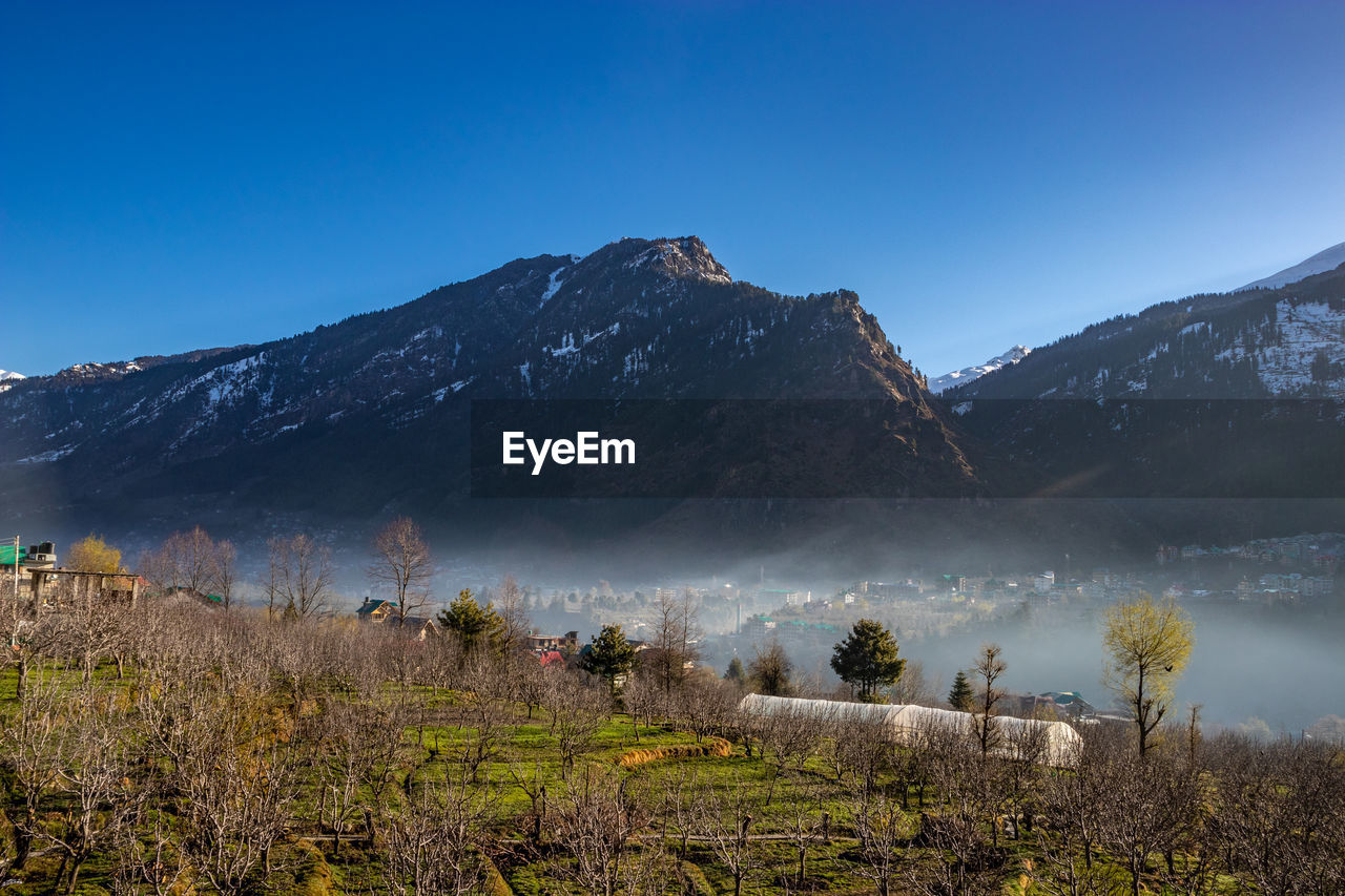 Scenic view of snowcapped mountains against clear blue sky