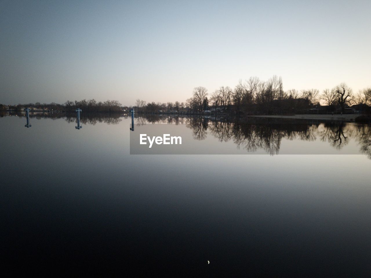 REFLECTION OF TREES IN LAKE AGAINST SKY