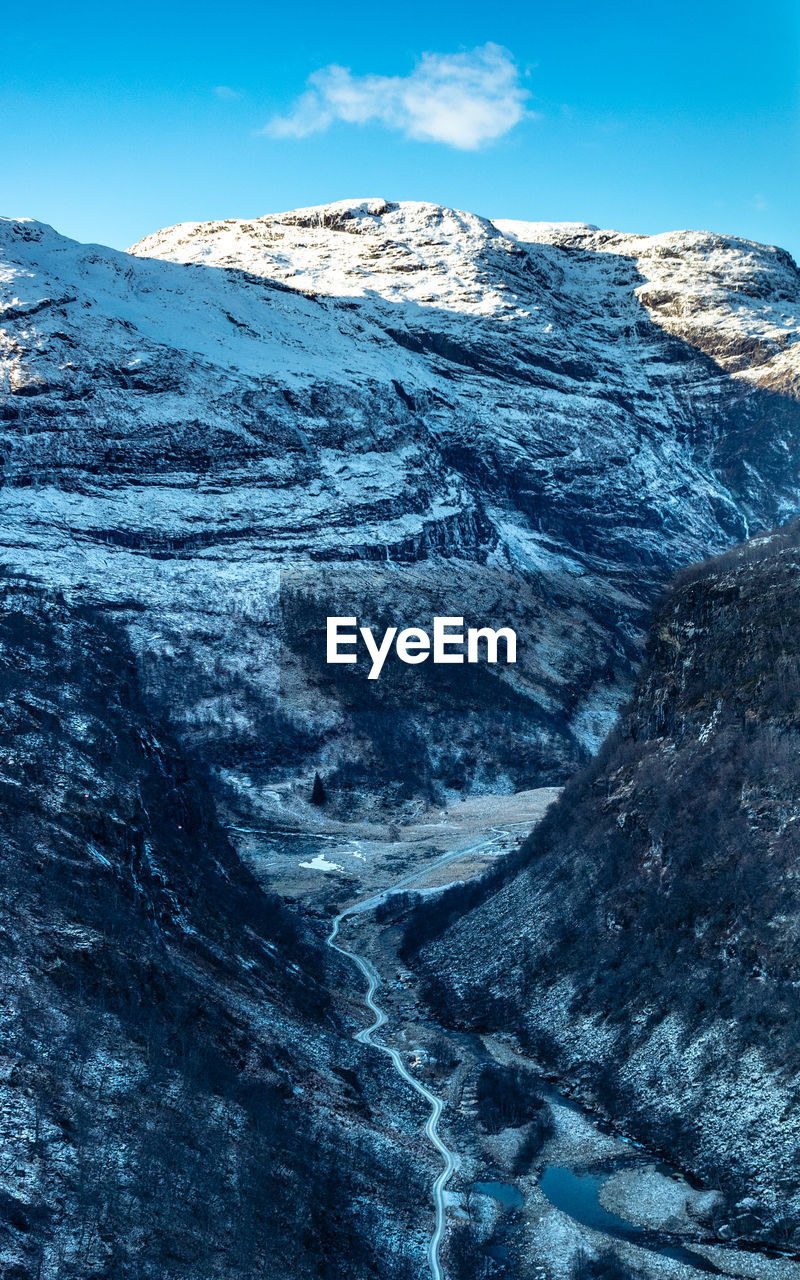 Scenic view of snowcapped mountains against blue sky