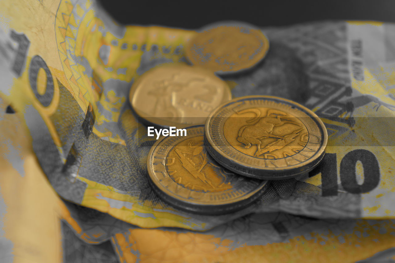 High angle view of coins on paper currency