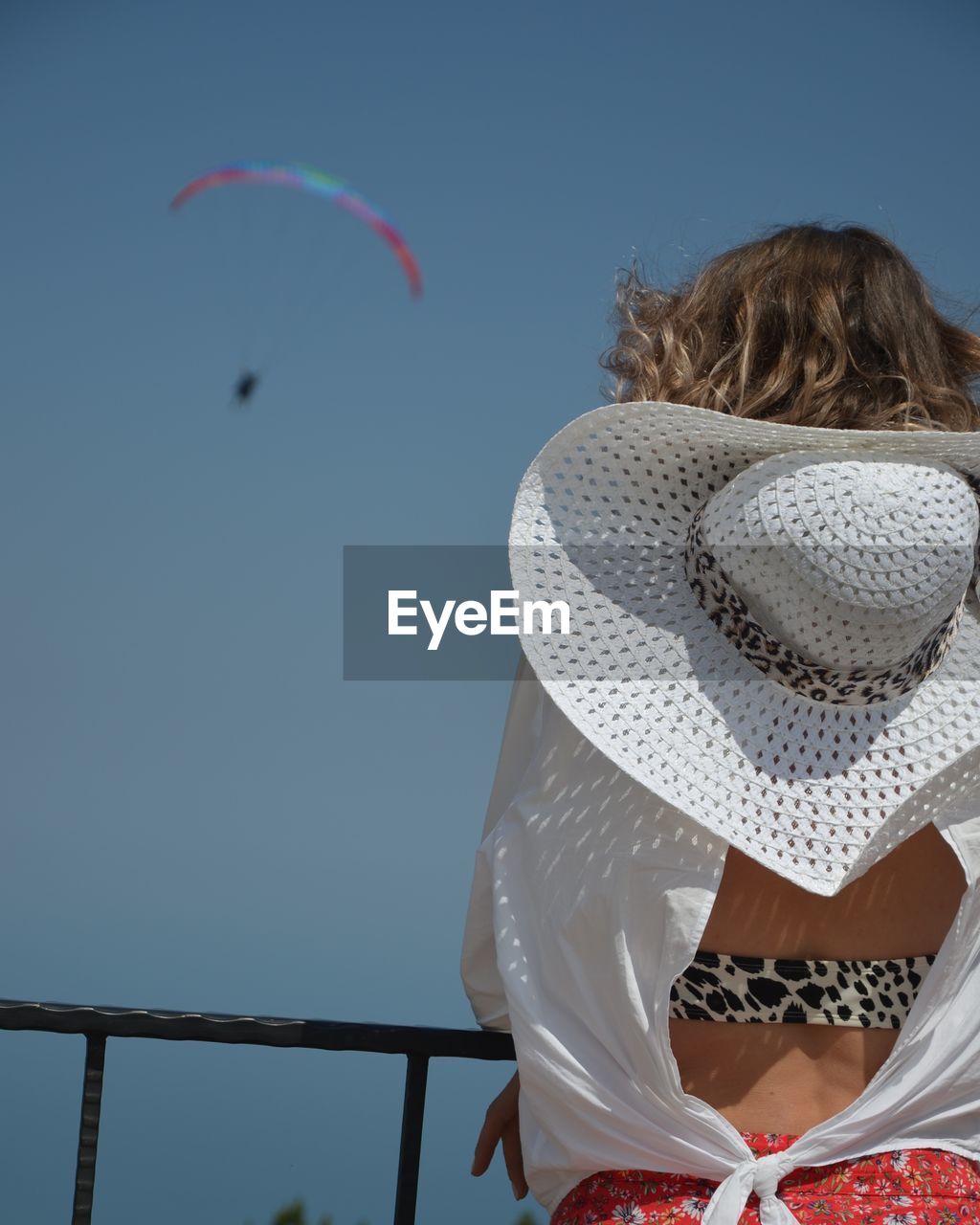 Rear view of woman flying against clear sky