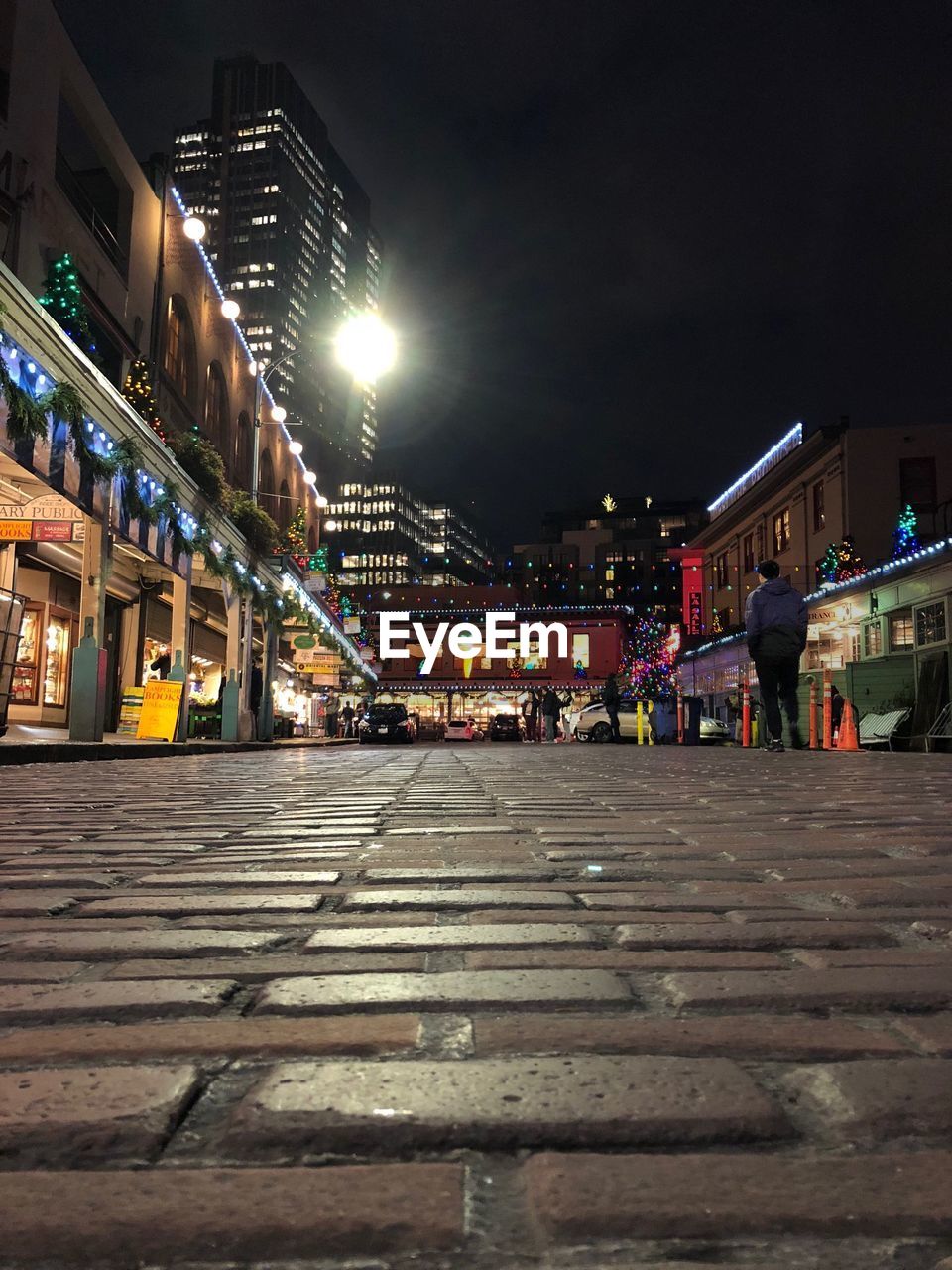 Illuminated city street against sky at night