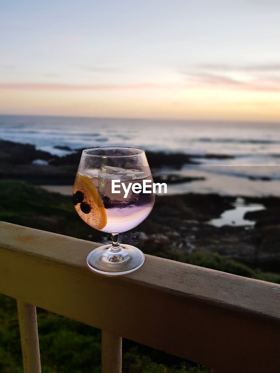 Close-up of gin on table against sky during sunset