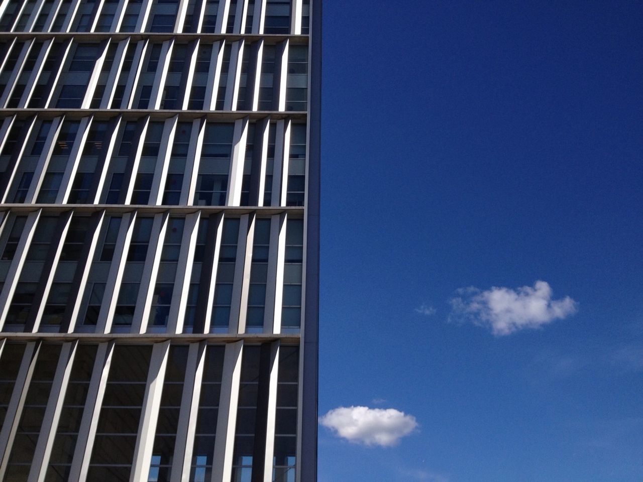 Cropped image of skyscraper against blue sky