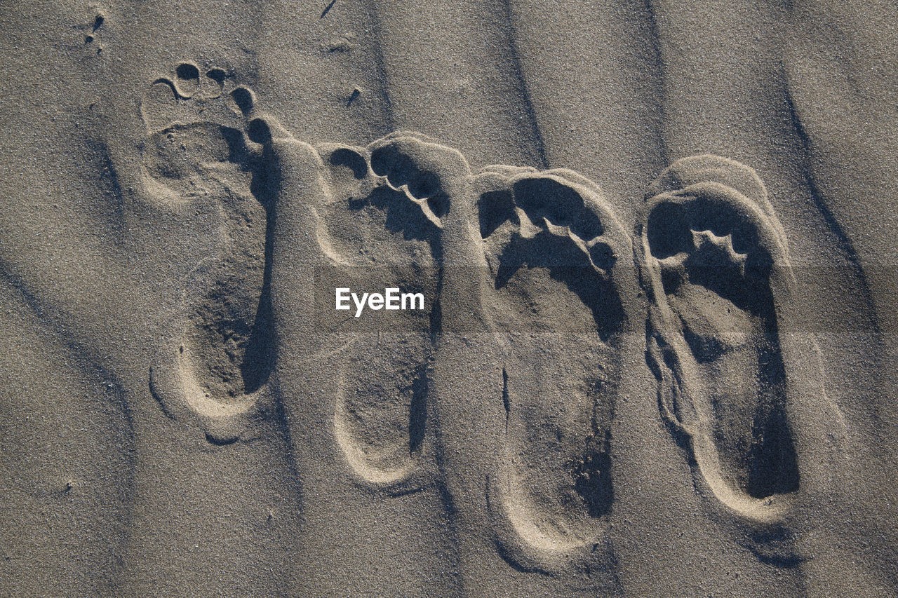 Directly above view of footprints on sand at beach