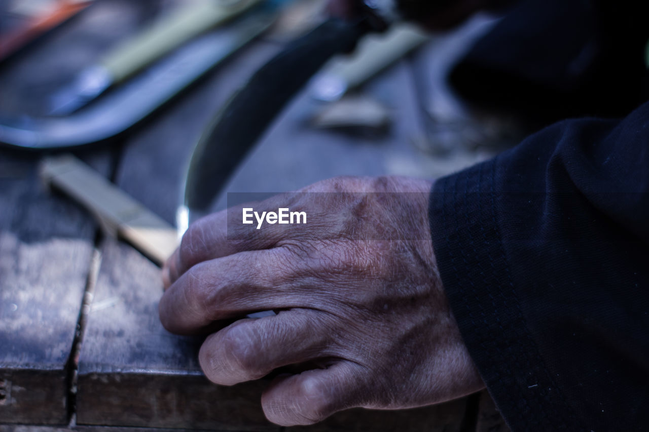 Close-up of man working on table in workshop