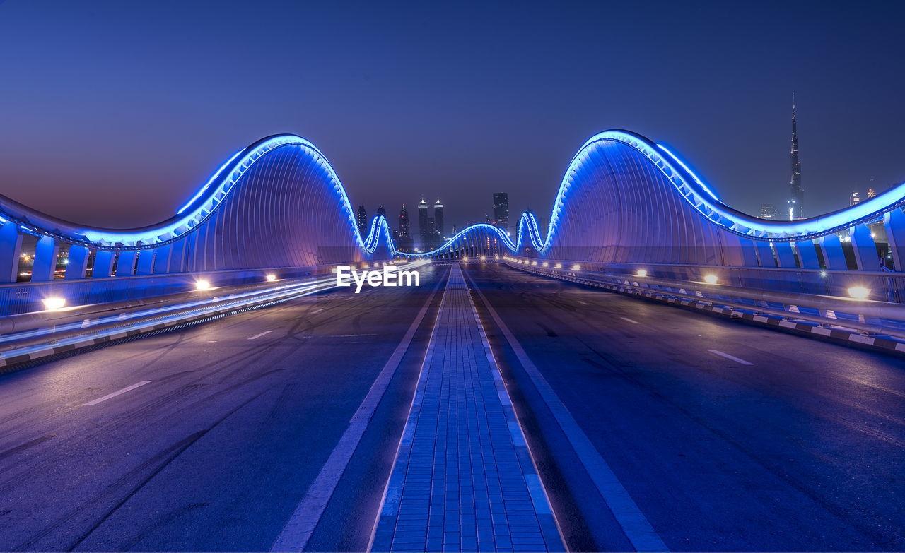 Illuminated bridge against sky at night