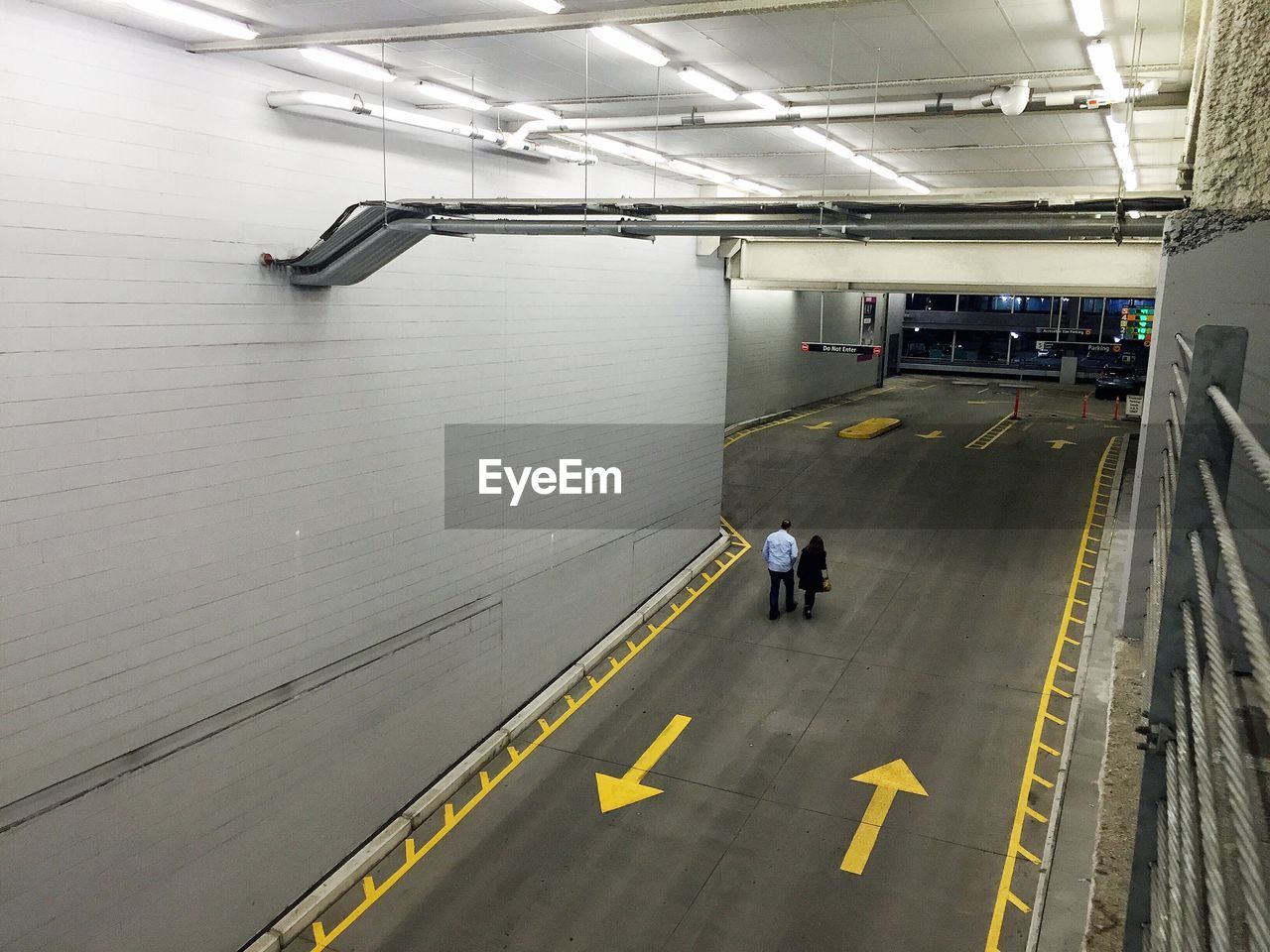High angle view of man and woman walking in parking lot