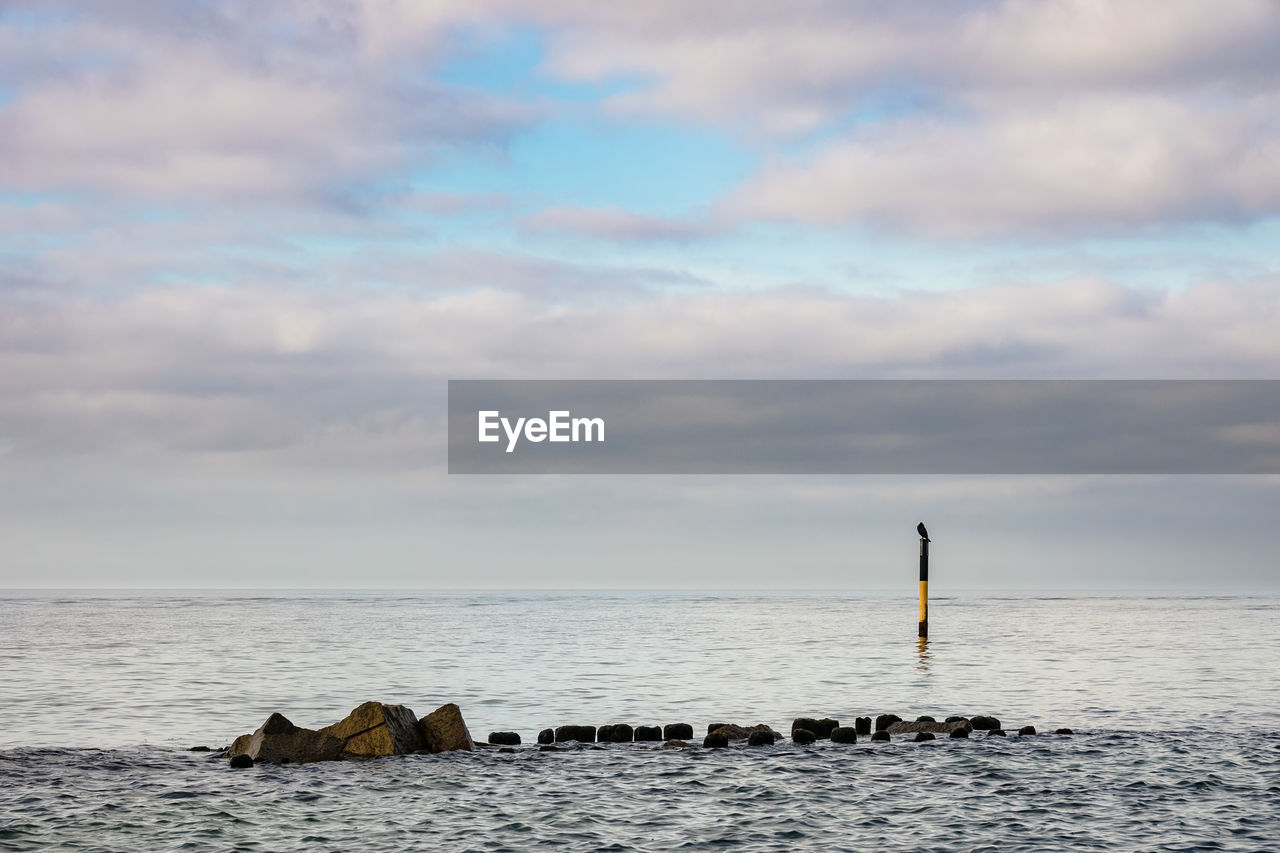 Scenic view of sea against cloudy sky