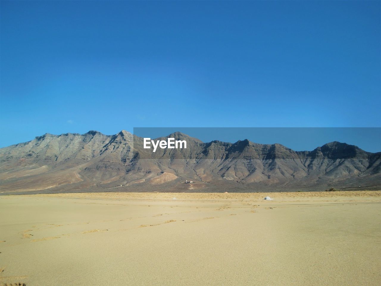 Scenic view of mountains against blue sky