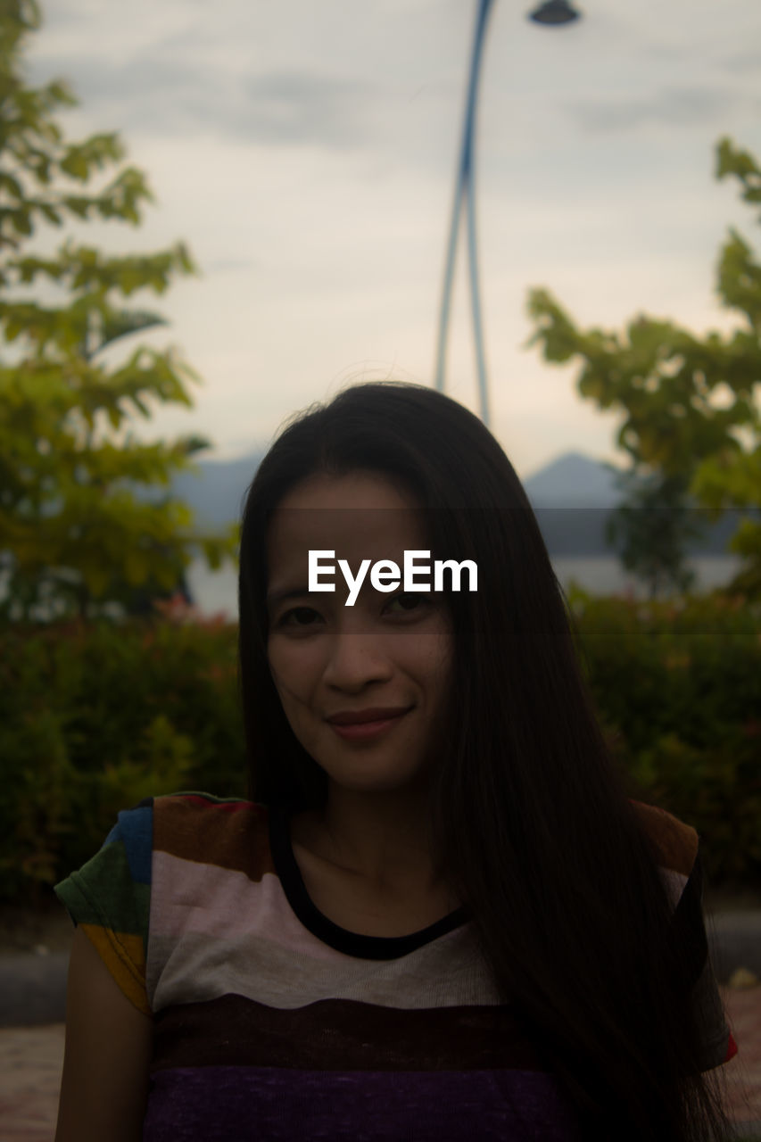 Portrait of smiling young woman at park