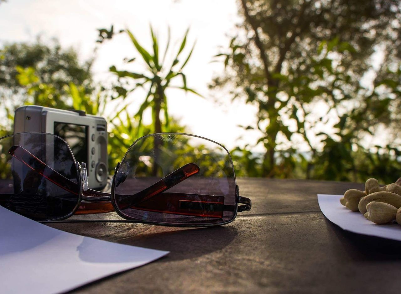 CLOSE-UP OF CAMERA ON TABLE AGAINST SKY