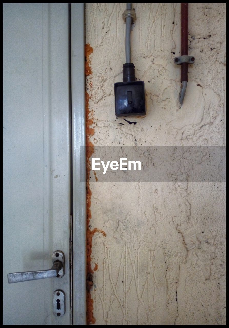 CLOSE-UP OF OLD DOOR HANDLE ON WALL