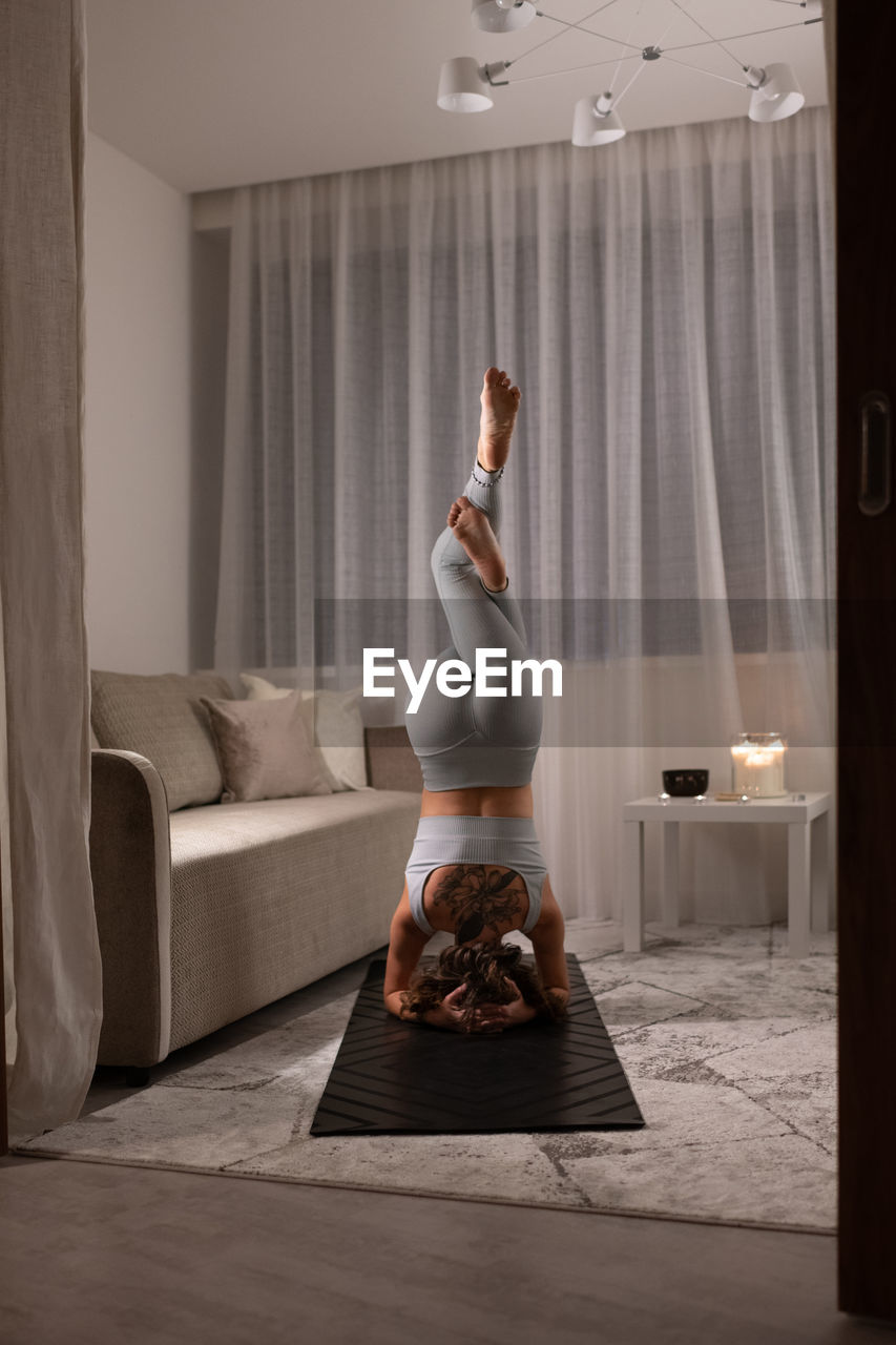 Unrecognizable woman doing eagle headstand