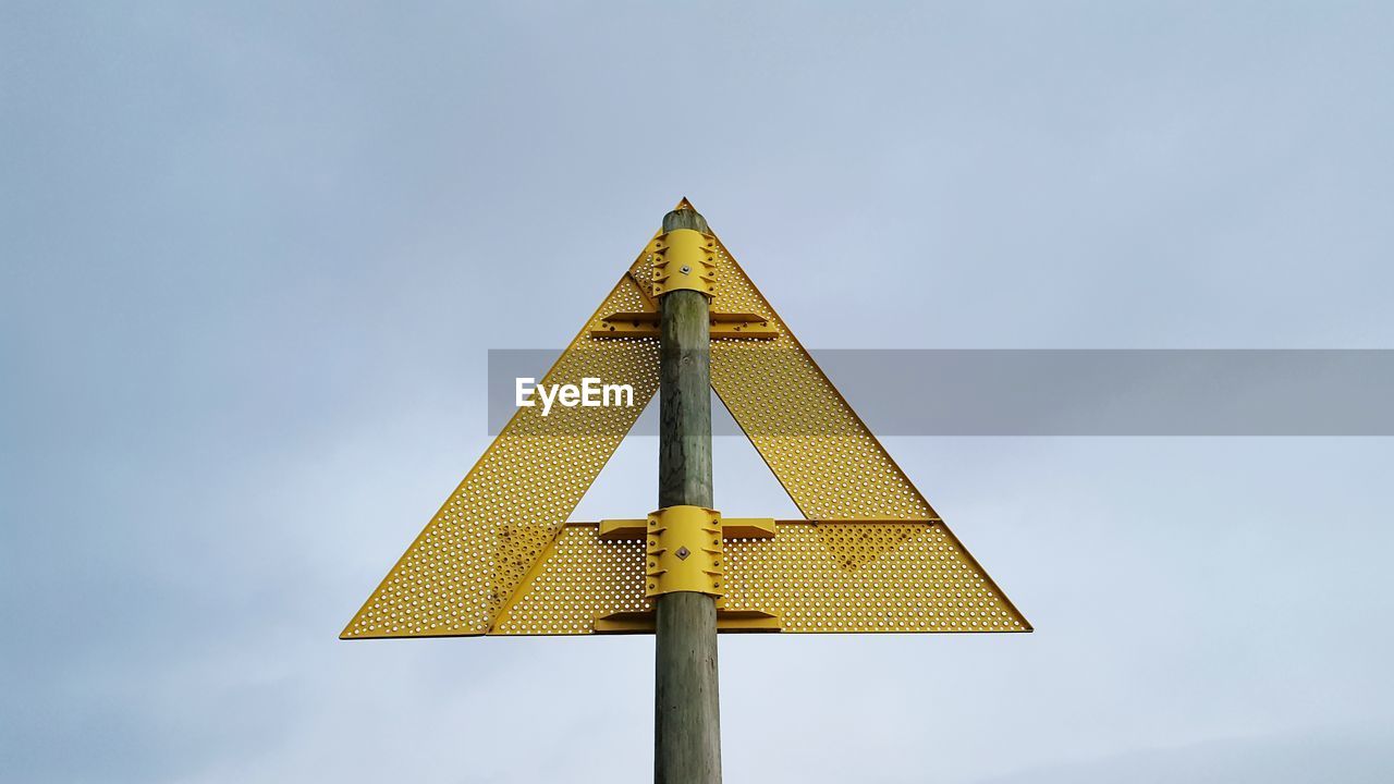 Low angle view of road sign against sky