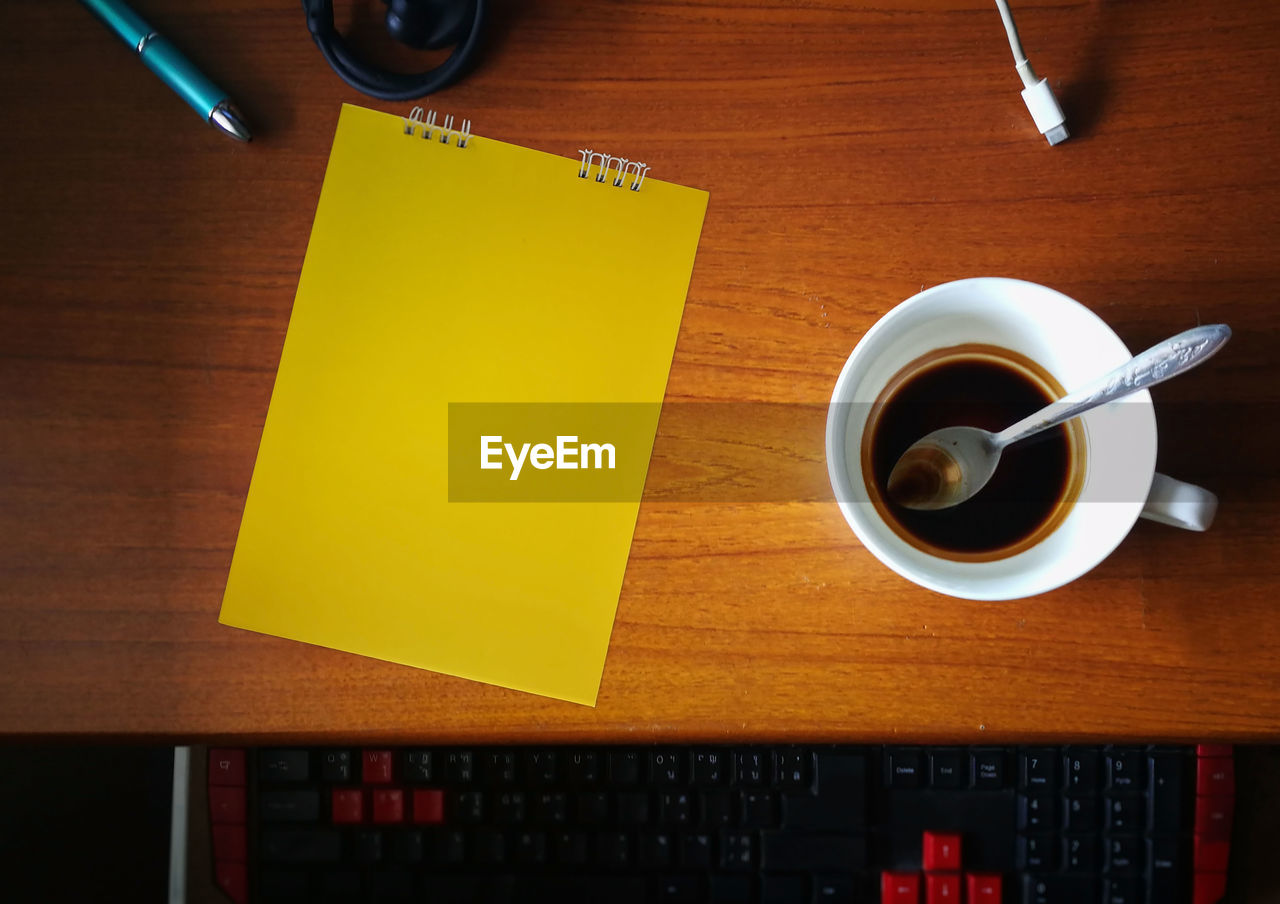 DIRECTLY ABOVE SHOT OF COFFEE CUP ON TABLE WITH OPEN