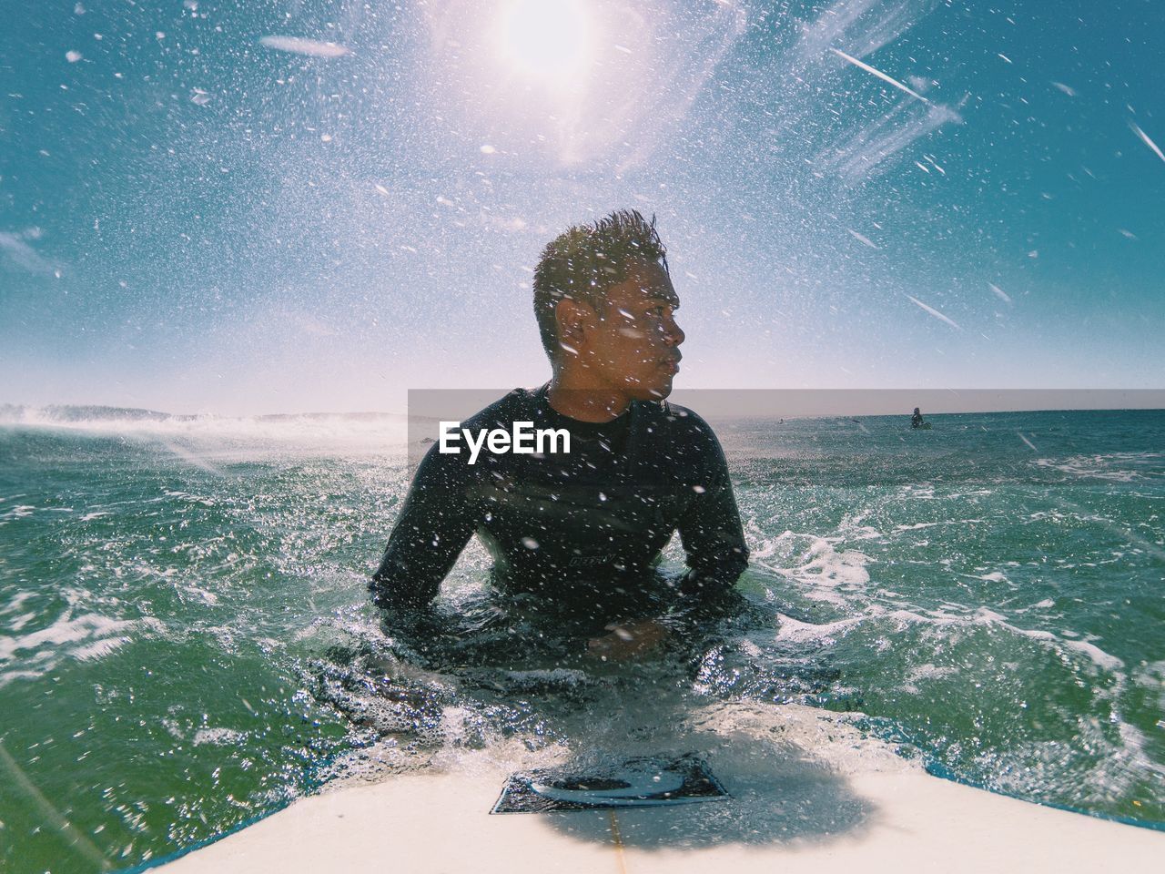 MAN SPLASHING WATER AGAINST SEA