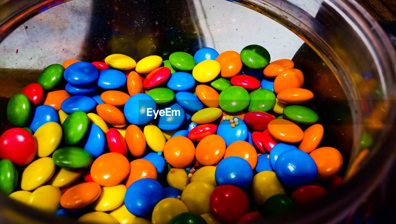 HIGH ANGLE VIEW OF COLORFUL CANDIES IN CONTAINER