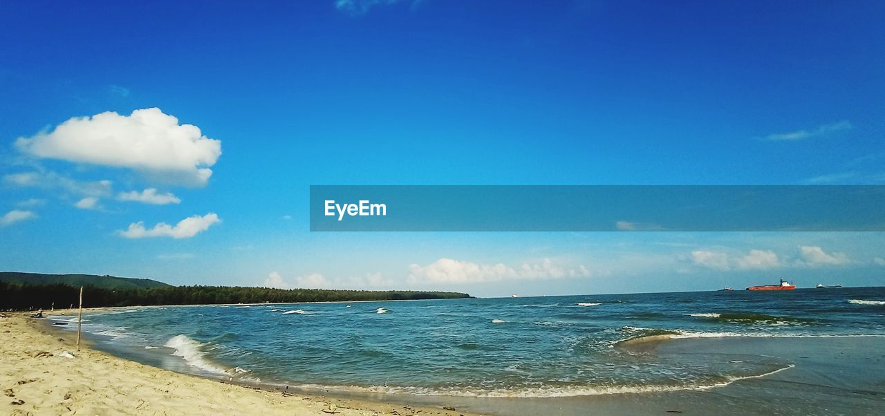 Scenic view of beach against blue sky