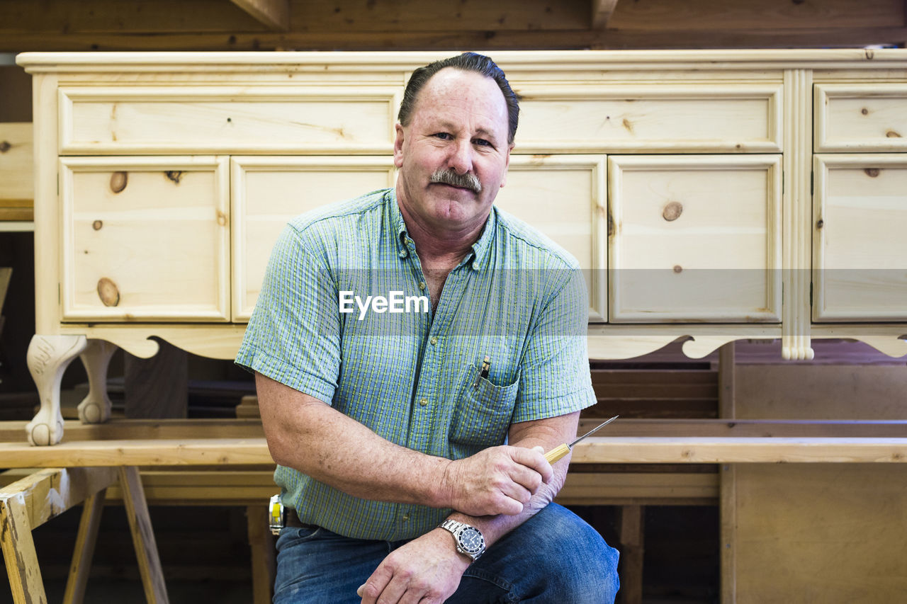 Portrait of confident carpenter at workshop