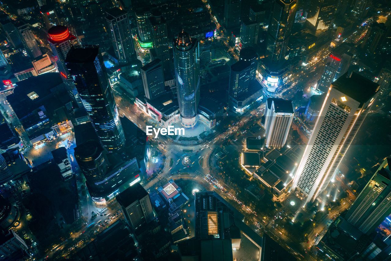 HIGH ANGLE VIEW OF ILLUMINATED CITY BUILDINGS AT NIGHT