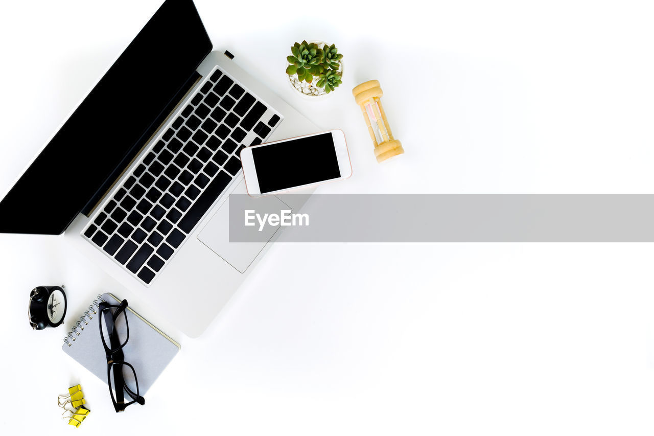 HIGH ANGLE VIEW OF LAPTOP ON WHITE TABLE