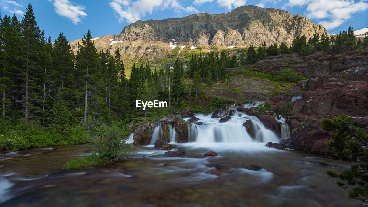 Stream flowing through rocks against mountain