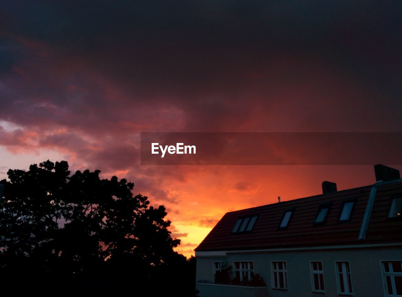 HIGH SECTION OF BUILT STRUCTURE AGAINST CLOUDY SKY AT SUNSET