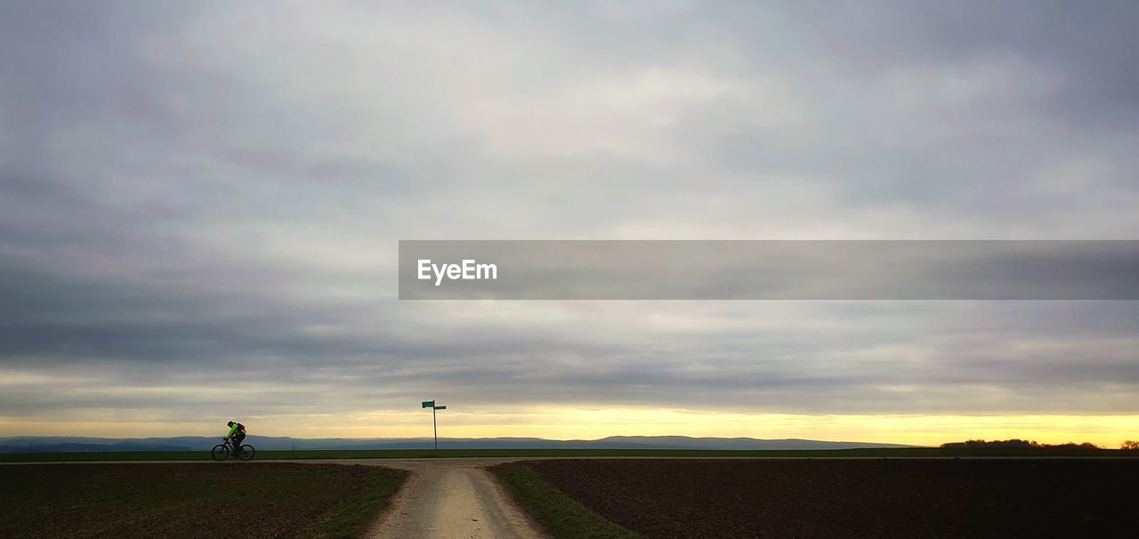 ROAD AMIDST FIELD AGAINST SKY