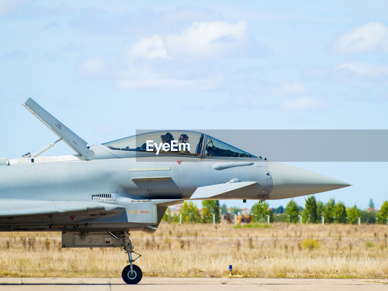 VIEW OF AIRPLANE FLYING OVER FIELD