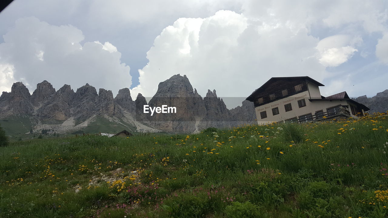 PANORAMIC SHOT OF BUILDINGS ON FIELD AGAINST SKY